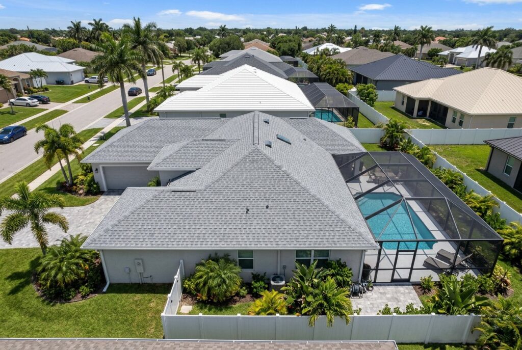 Aerial view of a home with a new shingle roof and pool